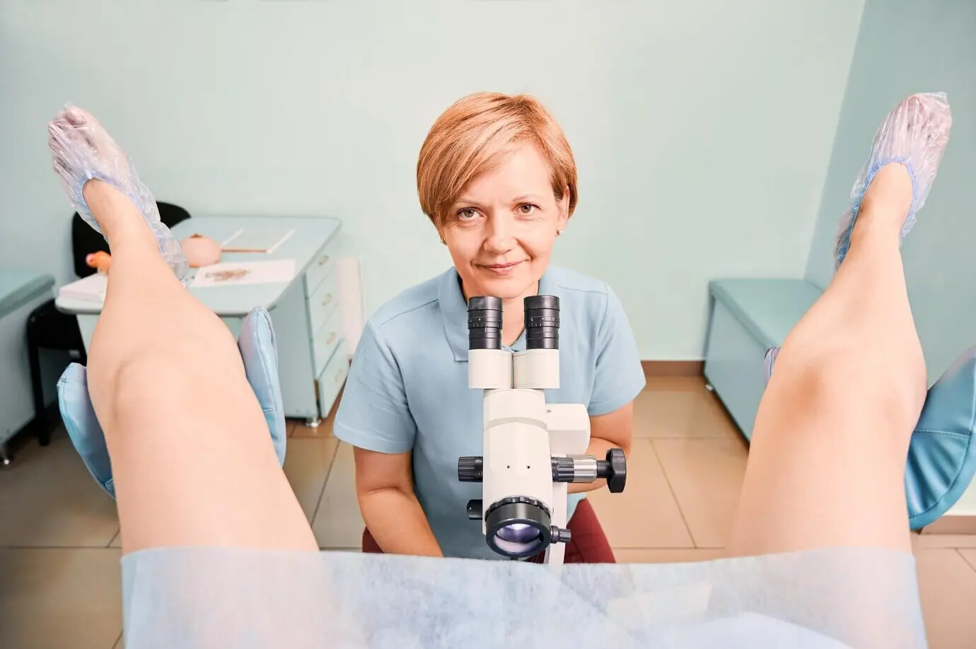 A friendly gynecologist examining a female patient in a clinic.